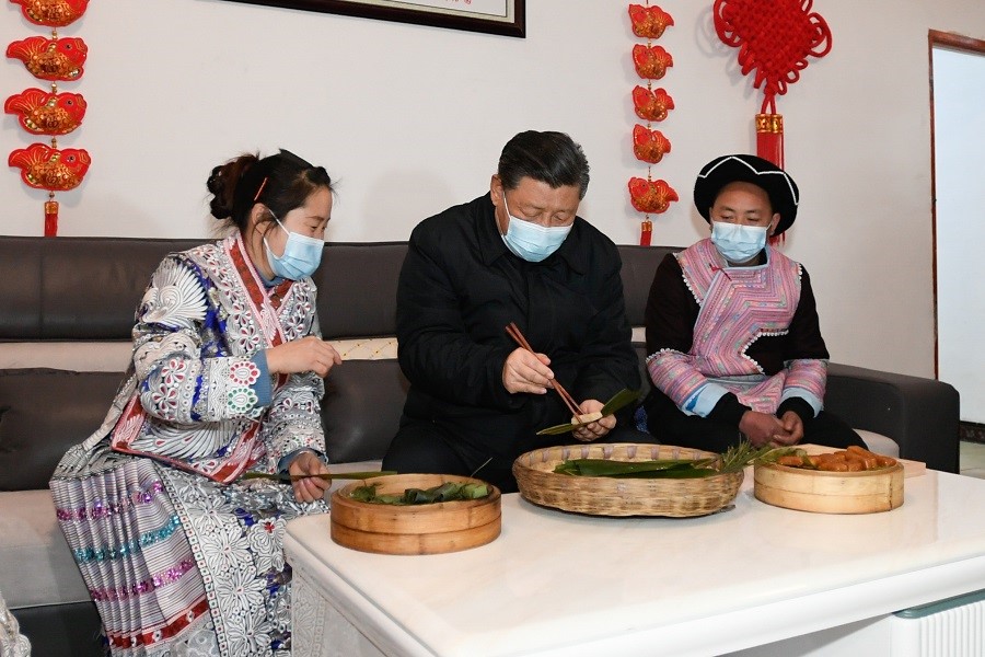 2021年2月3日下午，習(xí)近平在貴州畢節(jié)市黔西縣新仁苗族鄉(xiāng)化屋村苗族村民趙玉學(xué)家，同一家人邊聊家常邊制作當(dāng)?shù)貍鹘y(tǒng)節(jié)日食品黃粑。新華社記者 李學(xué)仁 攝